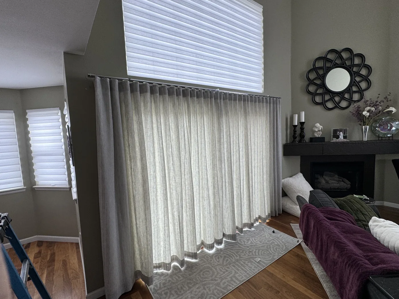 Floor-to-ceiling sheer linen drapery panels with traverse rod in a Boulder living room, custom installation by Howard's Draperies